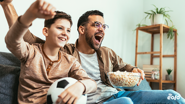 papà e bambino guardano partita calcio tv
